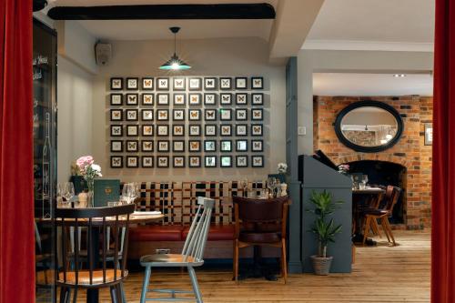 a restaurant with tables and chairs and a mirror at Cromwell Arms Country Pub with Rooms in Romsey