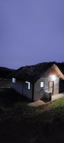 a small house with a thatched roof at night at Fazenda Espeto de Ouro in Cunha