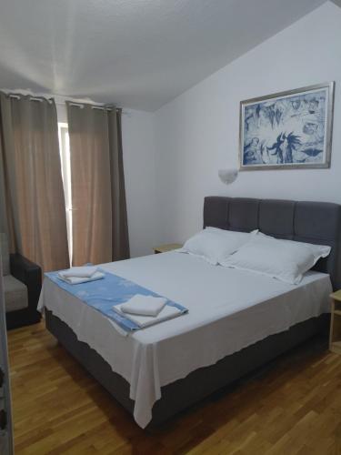 a bedroom with a large bed with white sheets at Apartments Galery in Makarska