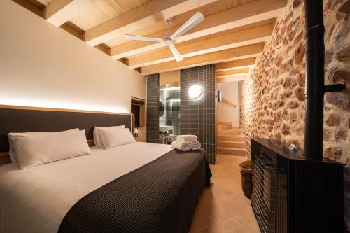 a bedroom with a bed and a brick wall at Apartamentos Vilafamés Antic Palau in Vilafames