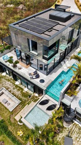 an aerial view of a house with a swimming pool at Saudade Residence - Ultra Luxury Futuristic Ocean Zen Retreat in Ribeira Brava
