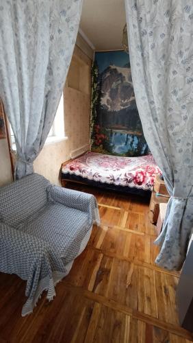 a room with a bed and a curtain and wooden floors at Jermuk apartment in Jermuk