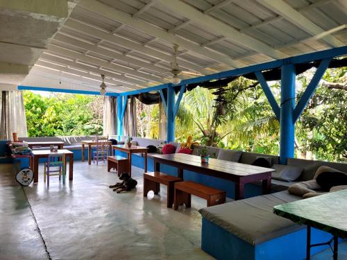 a living room with tables and couches and chairs at Hostel 23 in Las Terrenas