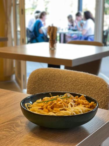 a bowl of pasta sitting on a table at Logis Hotel des Granges in Arles