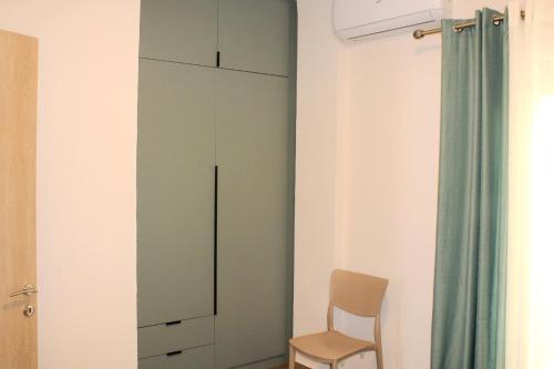 a room with a tall cabinet and a chair at Anthos Casa in Neos Marmaras