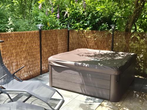 a bed sitting next to a chair and a fence at Počitniška hiša z dvema spalnicama Sauna & Jacuzzi in Gorica pri Slivnici