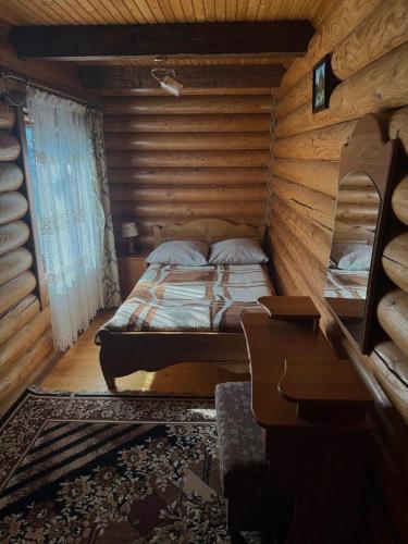 a bedroom with a bed in a log cabin at На Кружалі in Vorokhta