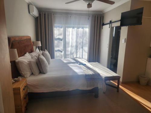 a bedroom with a large bed with a window at The Hills at 1 Meeu in Newcastle
