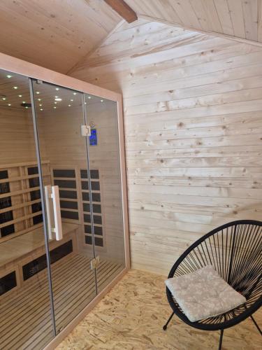 a chair sitting in a room with a shower at Počitniška hiša z dvema spalnicama Sauna & Jacuzzi in Gorica pri Slivnici