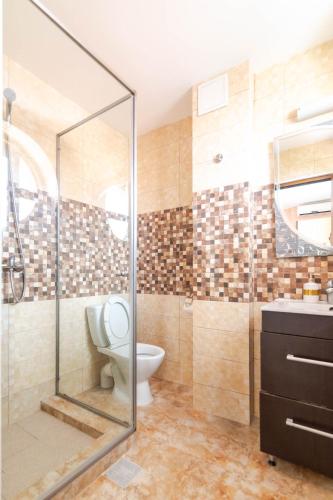 a bathroom with a toilet and a glass shower at Rosiem House in Techirghiol