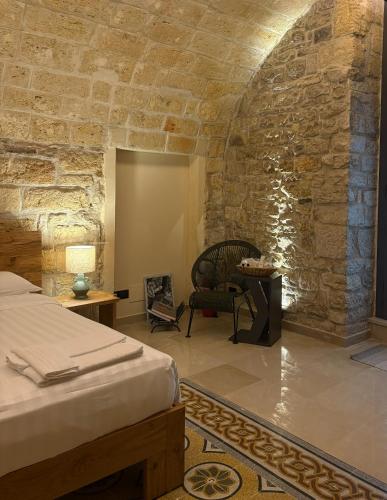 a bedroom with a bed and a stone wall at Terra di Trani in Trani