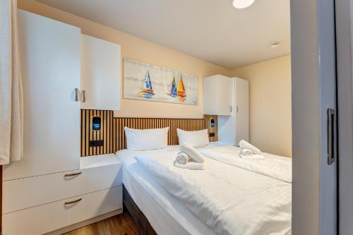 een slaapkamer met twee bedden met witte lakens bij Dünenhäuser Ückeritz UnserUsedomDe FeWo ca40qm mit Parkplatz direkt am Strand 9I1 in Ueckeritz