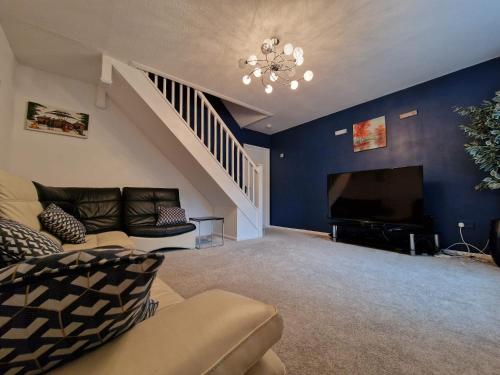 a living room with a couch and a television at A spare room in a quite cul de sac in New Bilton