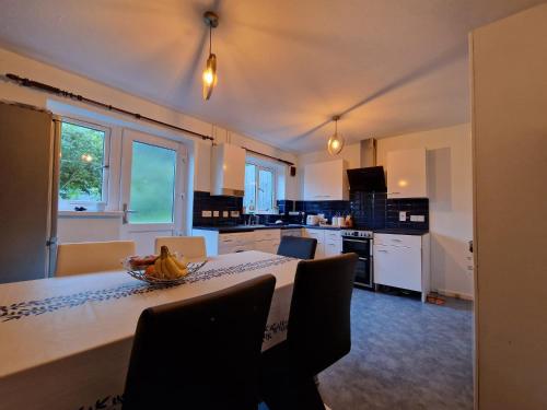 a kitchen with a table with a bowl of bananas on it at A spare room in a quite cul de sac in New Bilton