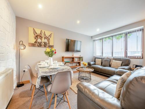 ein Wohnzimmer mit Sofa und Tisch in der Unterkunft The Granary - Uk41502 in Saint Twynnells