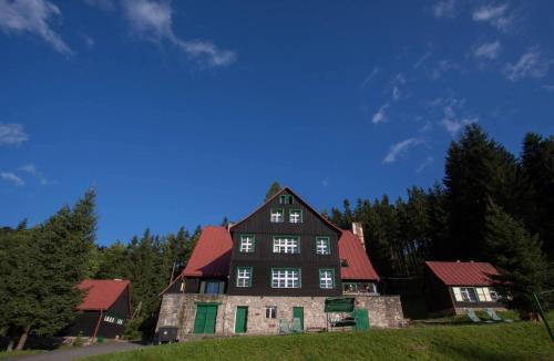 an old house with a red roof on a hill at Górska Perła Pokoje Gościnne in Międzylesie