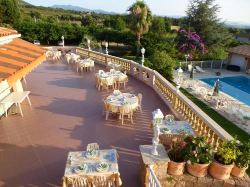 um pátio exterior com mesas e cadeiras e uma piscina em Auberge U Licettu em Cuttoli-Corticchiato