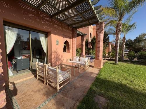 a patio with chairs and a table on a house at Appartement standing piscine la palmeraie in Marrakech