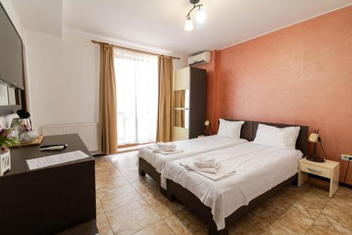 a bedroom with a large bed and a desk at Rosiem House in Techirghiol