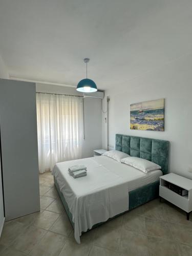 a bedroom with a large bed and a pendant light at Joni's Twin Condos (Pool&Pine View) in Golem