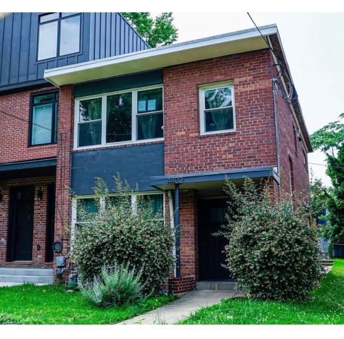 a brick house with a door and two bushes at Cozy 1BR Basement Unit with Private Entry & Free Parking in Washington, D.C.