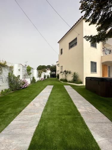 a house with a green lawn and a sidewalk at REQUESENS Playa in Empuriabrava