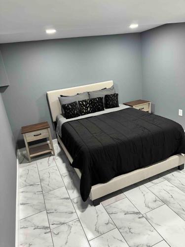 a bedroom with a large black bed and a blue wall at Cozy 1BR Basement Unit with Private Entry & Free Parking in Washington, D.C.