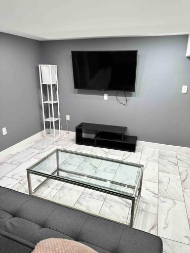 a living room with a couch and a flat screen tv at Cozy 1BR Basement Unit with Private Entry & Free Parking in Washington, D.C.
