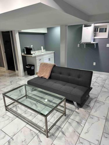 a living room with a black couch and a glass table at Cozy 1BR Basement Unit with Private Entry & Free Parking in Washington, D.C.