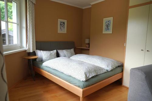 a bedroom with a bed with white sheets and a window at Appartement Genigau in Wagrain