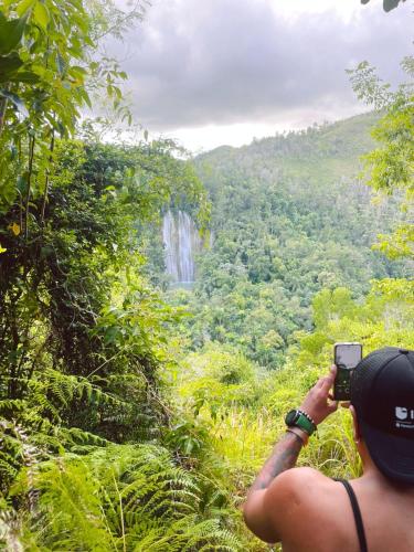a man taking a picture of a waterfall at Hostel 23 in Las Terrenas