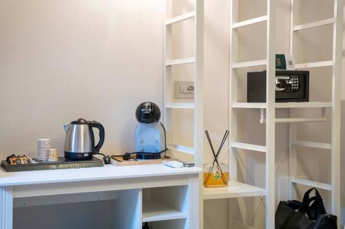 a white shelf with a coffee maker on a table at Corte Atenea Guest House Experience & Spa in Agrigento