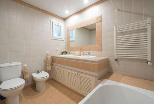 a bathroom with a toilet and a sink and a mirror at Luxury VILLA CAMÉLIA. Mountains, golf, horses, levada walks. in Santo da Serra