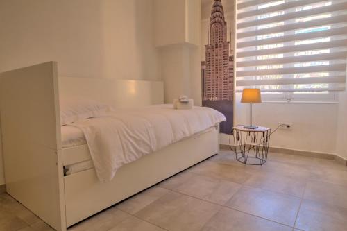 une chambre blanche avec un lit et une table dans l'établissement ALC - CAR40 - 11 min Palais - beaches, à Cannes