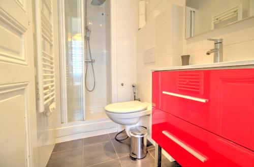 La salle de bains rouge est pourvue d'une douche et de toilettes. dans l'établissement ALC - CAR40 - 11 min Palais - beaches, à Cannes