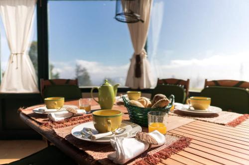 a wooden table with plates of food on top of it at Luxury VILLA CAMÉLIA. Mountains, golf, horses, levada walks. in Santo António da Serra