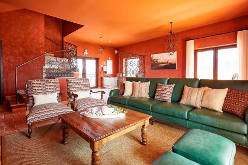 ein Wohnzimmer mit einem grünen Sofa und einem Tisch in der Unterkunft Silver Coast Beach Residence in Baleal