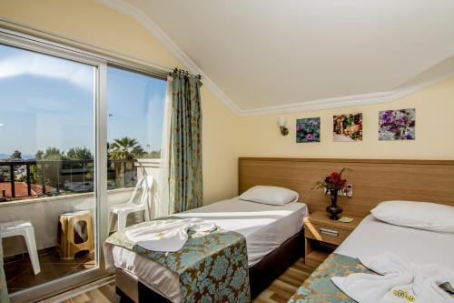 a hotel room with two beds and a window at Magic Tulip Hotel in Oludeniz