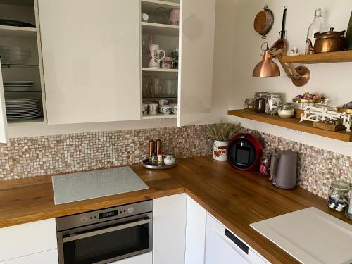 a kitchen with white cabinets and wooden counter tops at Apartments Loket No 59 se zahradou in Loket