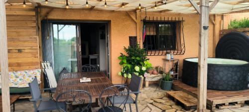 Jolie maison avec spa exterieur في مونبلييه: فناء مع طاولة وحوض استحمام