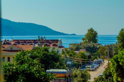 a town with cars parked in a parking lot next to the ocean at Magic Tulip Hotel in Oludeniz