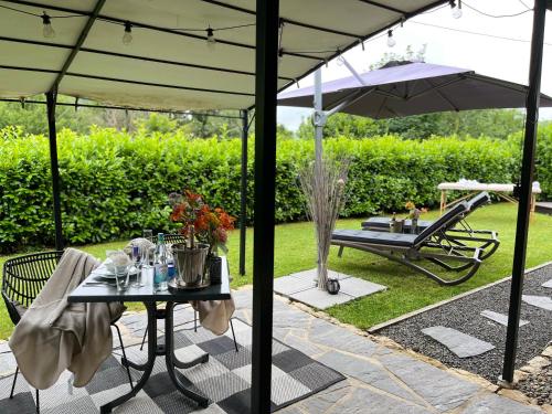 a patio with a table and an umbrella at Relax-Bollendorf in Bollendorf