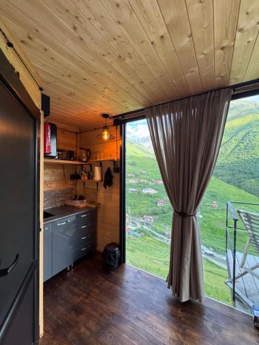 a kitchen with a large window in a tiny house at Pirdapira in Jut'a