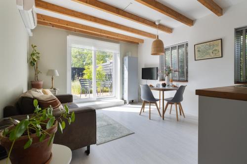 a living room with a table and chairs at Vakantiehuisje Grijpskerke, hartje Walcheren in Grijpskerke
