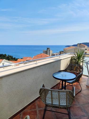 a patio with two chairs and a table on a balcony at Mila & Aleksandr Apartments in Budva