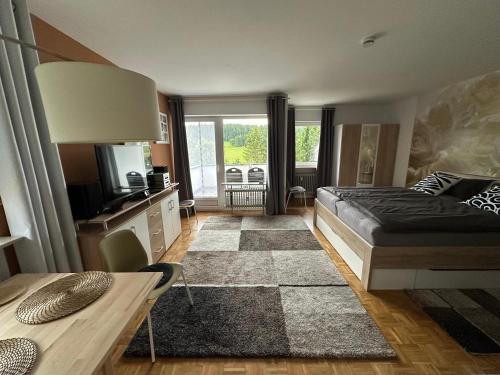 een slaapkamer met een bed en een televisie en een tafel bij Haus - Sonneck in Schönwald