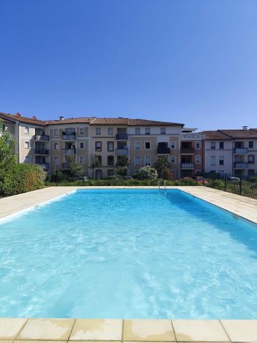 a large swimming pool in front of a building at Mentor au coeur de Grenade -wifi-piscine-parking privé in Grenade-sur-Garonne