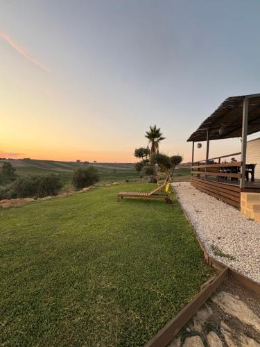 a grassy field with a pavilion and a palm tree at Casa vacanze Trinacria in Menfi