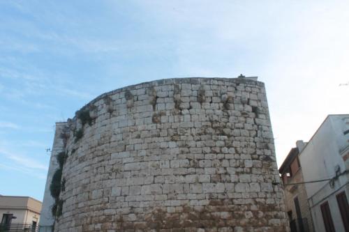 a tall brick building with a sky in the background at Dioniso Affittacamere in Conversano