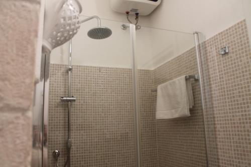 a shower with a glass door in a bathroom at Dioniso Affittacamere in Conversano